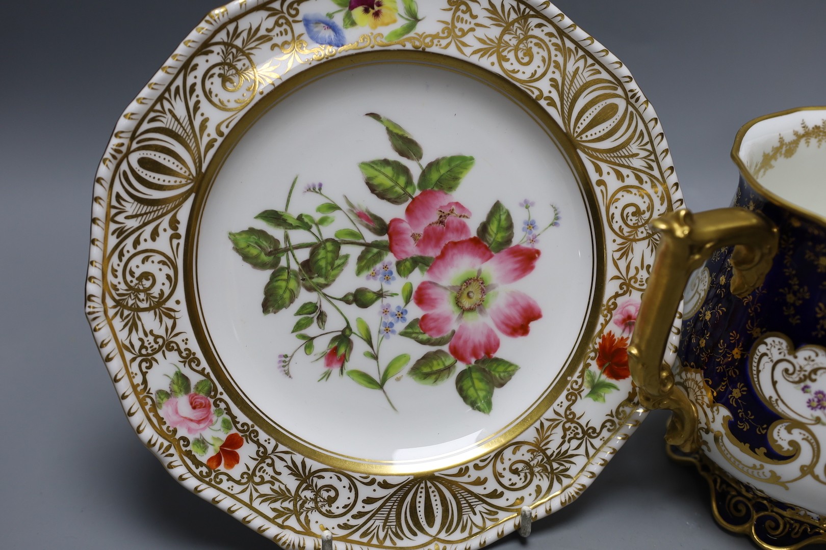 A Derby King Street plate by Harry Sampson Hancock monogrammed verso 'II' red S and H mark and a Royal Crown Derby three handled loving cups